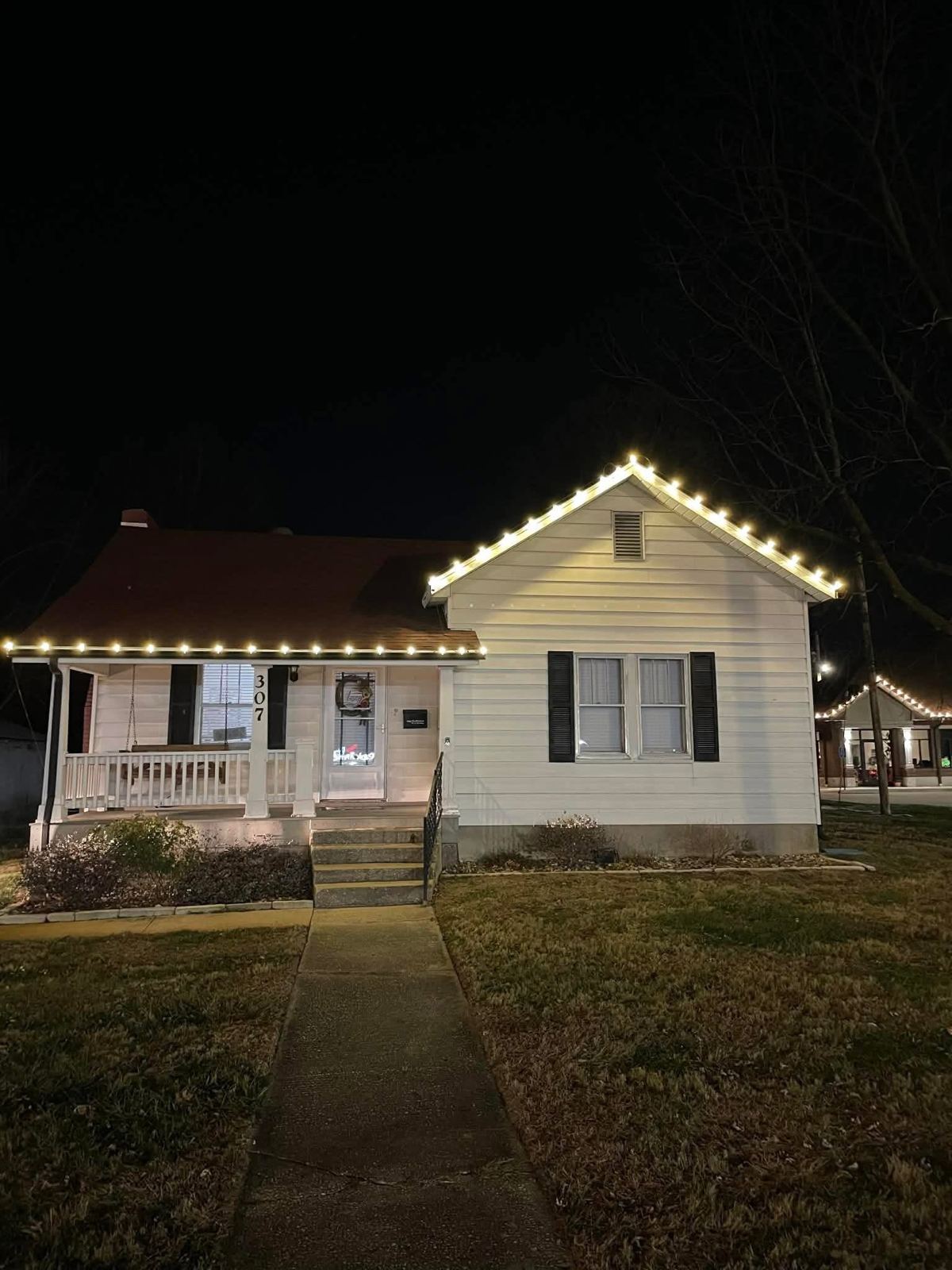 Cottage with warm white porch and gable lights