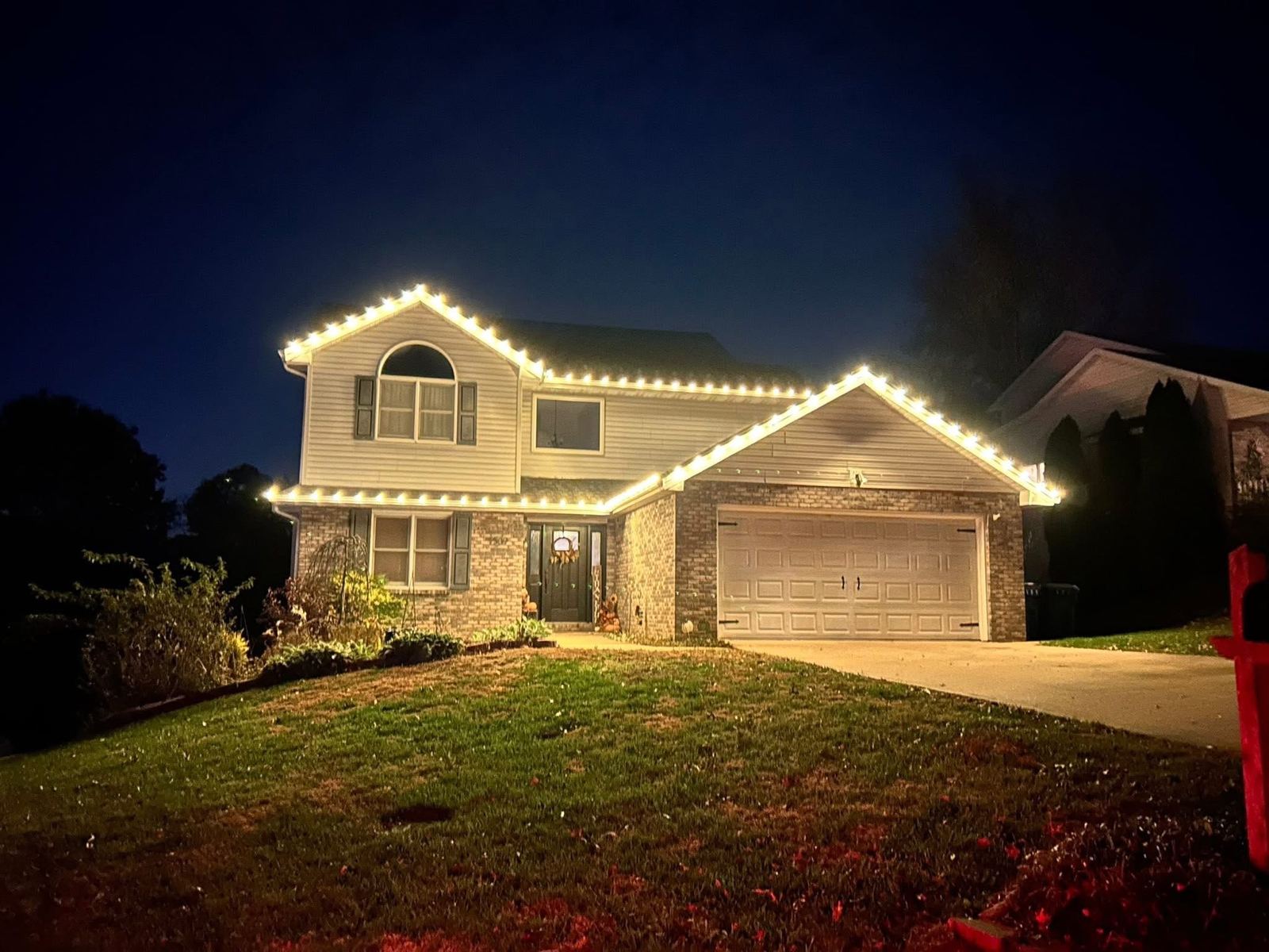 Two-story home with warm white roofline lights